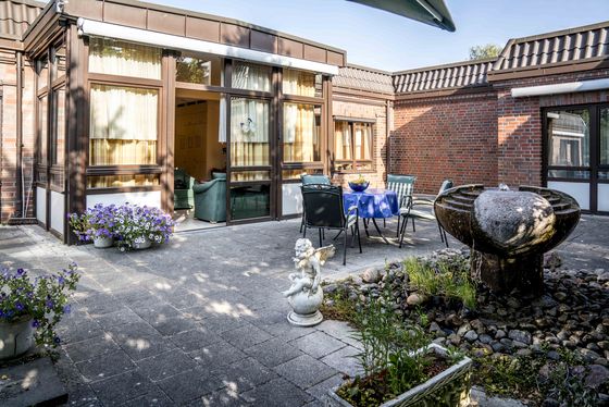 Garten und Terasse mit Gartenstühlen und Tisch der Autonomen stationären Wohngemeinschaft Garten und Terasse mit Gartenstühlen und Tisch der Autonomen stationären Wohngemeinschaft