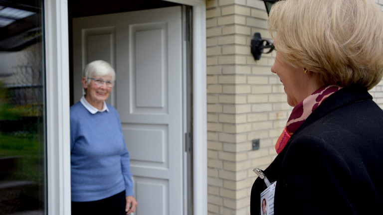 Eine Seniorin begrüßt eine Beraterin an der Haustür beim Projekt Hamburger Hausbesuch für Seniorinnen und Senioren der Stadt Hamburg mit dem Albertinen Haus - Zentrum für Geriatrie und Gerontologie