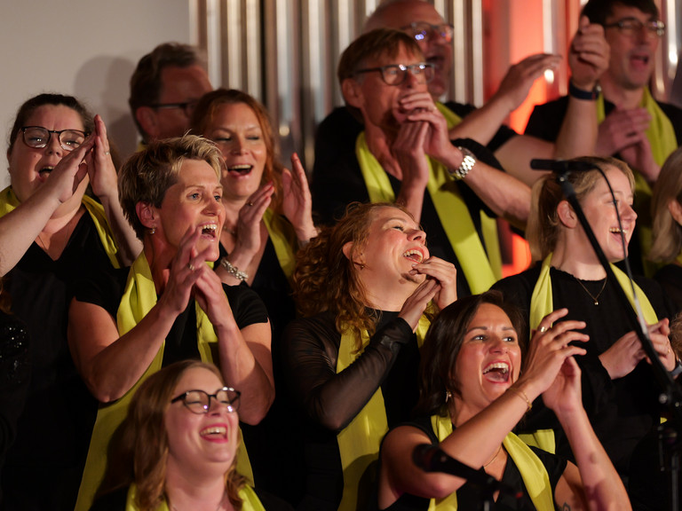 Mehrere in die Hände klatschende Sängerinnen und Sänger des Albertinen Mitarbeitenden Gospelchors im bunt beleuchteten Kirchenraum der Kirche am Albertinen Krankenhaus in Hamburg. Mehrere in die Hände klatschende Sängerinnen und Sänger des Albertinen Mitarbeitenden Gospelchors im bunt beleuchteten Kirchenraum der Kirche am Albertinen Krankenhaus in Hamburg.